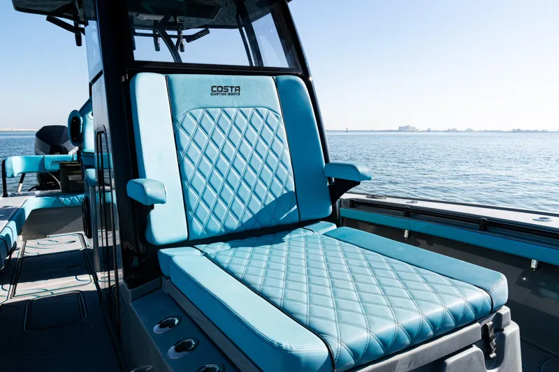  Yacht Photos Pics 2022 Costa Custom Boats 264 with luxurious blue seating on a calm sea.