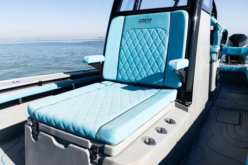  Yacht Photos Pics Luxurious seating on 2022 Costa Custom Boats 264, featuring blue diamond-stitched upholstery.