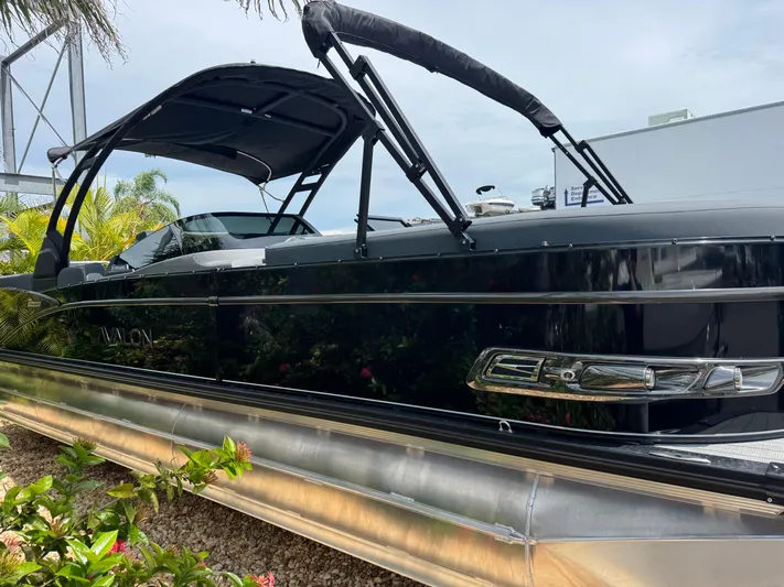  Yacht Photos Pics 2025 Avalon Catalina Platinum Quad Lounge boat, sleek black design, docked outdoors.