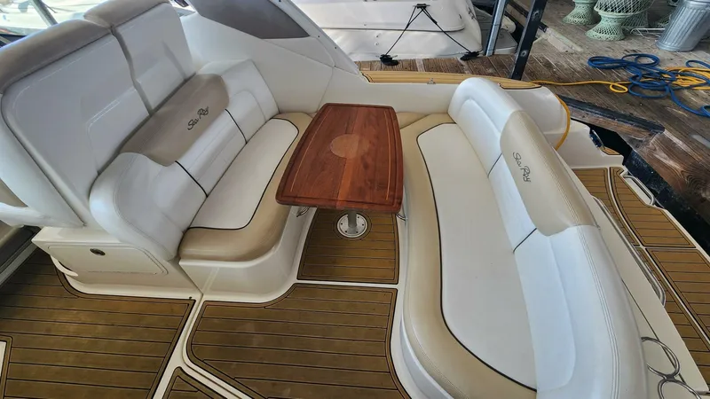 Back In The Game Yacht Photos Pics 2008 Sea Ray 310 Sundancer interior with cushioned seating and wooden table.