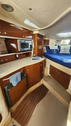 Back In The Game Yacht Photos Pics Interior of 2008 Sea Ray 310 Sundancer with wood cabinetry and blue bedding.