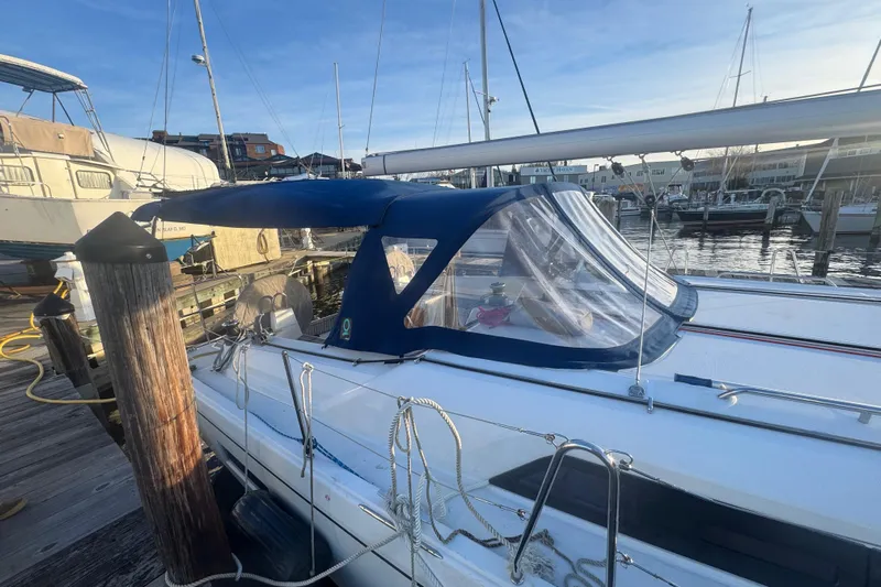 Sway Yacht Photos Pics 2023 Beneteau Oceanis 40.1 sailboat docked at marina, featuring blue canopy.
