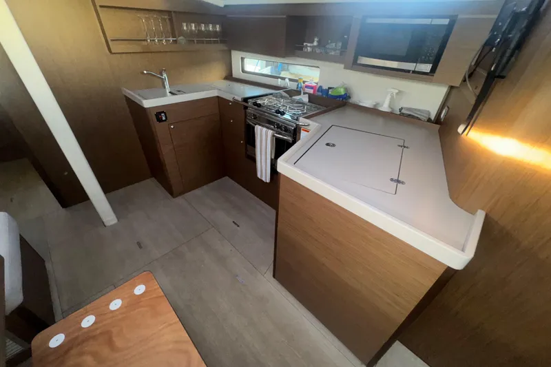 Sway Yacht Photos Pics 2023 Beneteau Oceanis 40.1 yacht interior kitchen with modern appliances and wood finish.