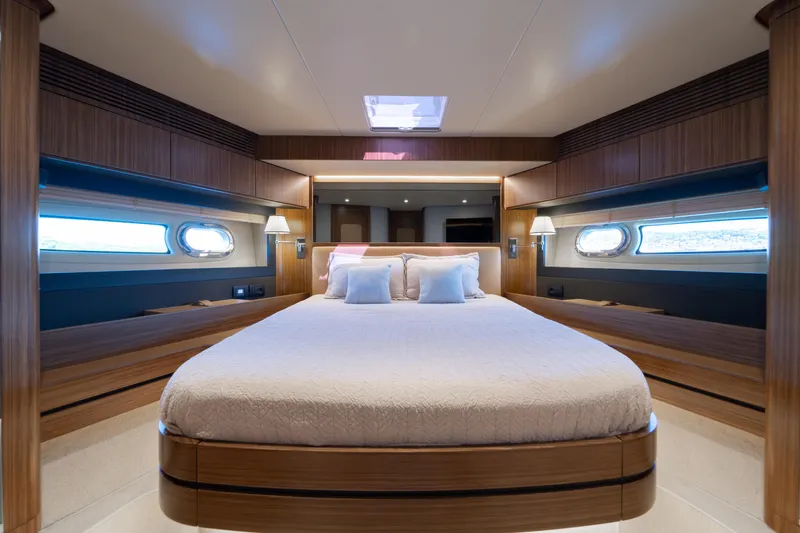 Izi Yacht Photos Pics Luxurious bedroom interior of 2017 Azimut Magellano 66 yacht with elegant wood finishes.