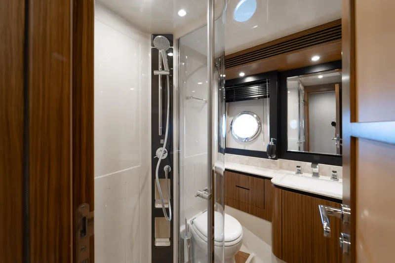 Izi Yacht Photos Pics Luxurious bathroom in 2017 Azimut Magellano 66 yacht with modern fixtures and porthole window.