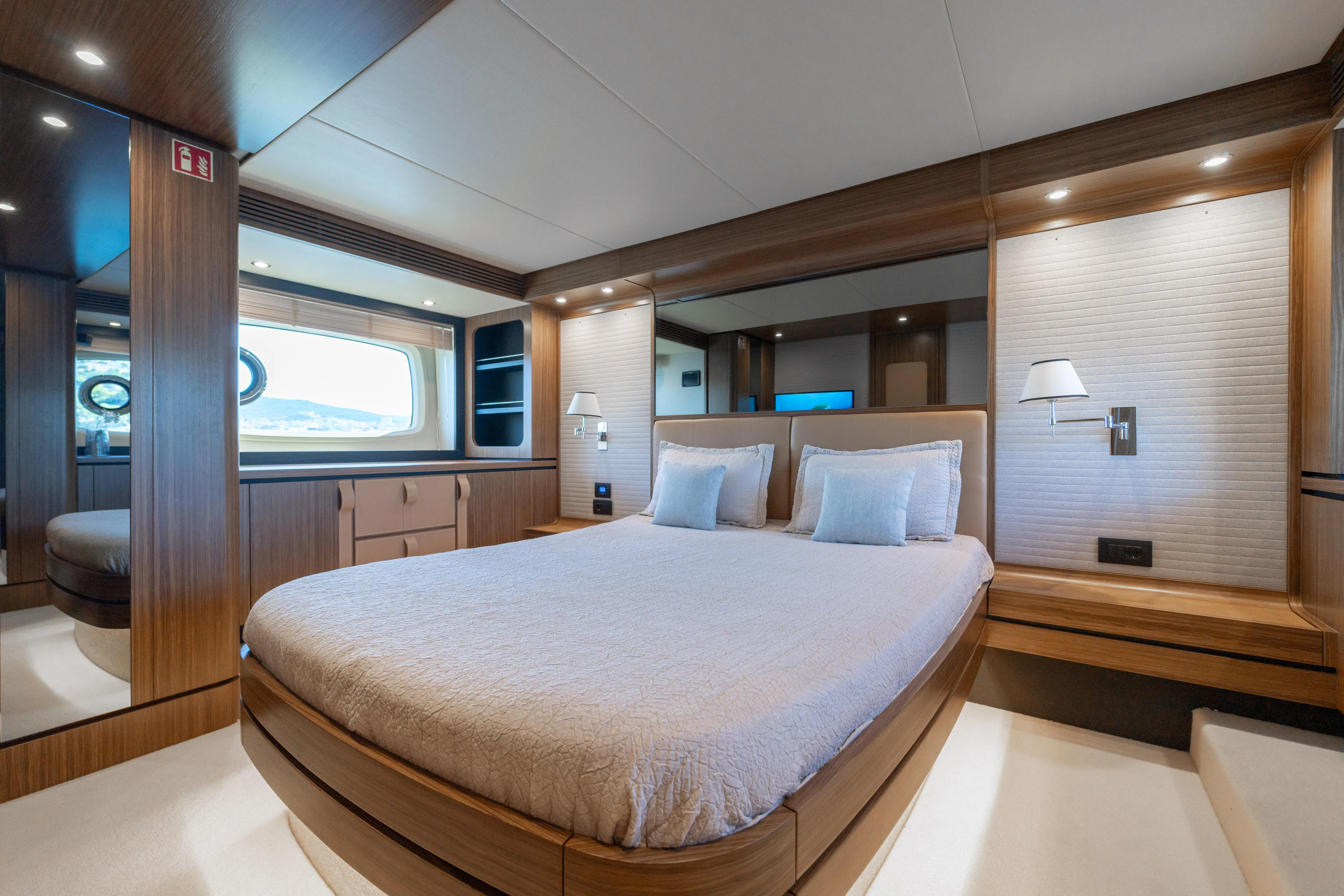 Izi Yacht Photos Pics Luxurious bedroom interior on 2017 Azimut Magellano 66 yacht, featuring elegant wood finishes.