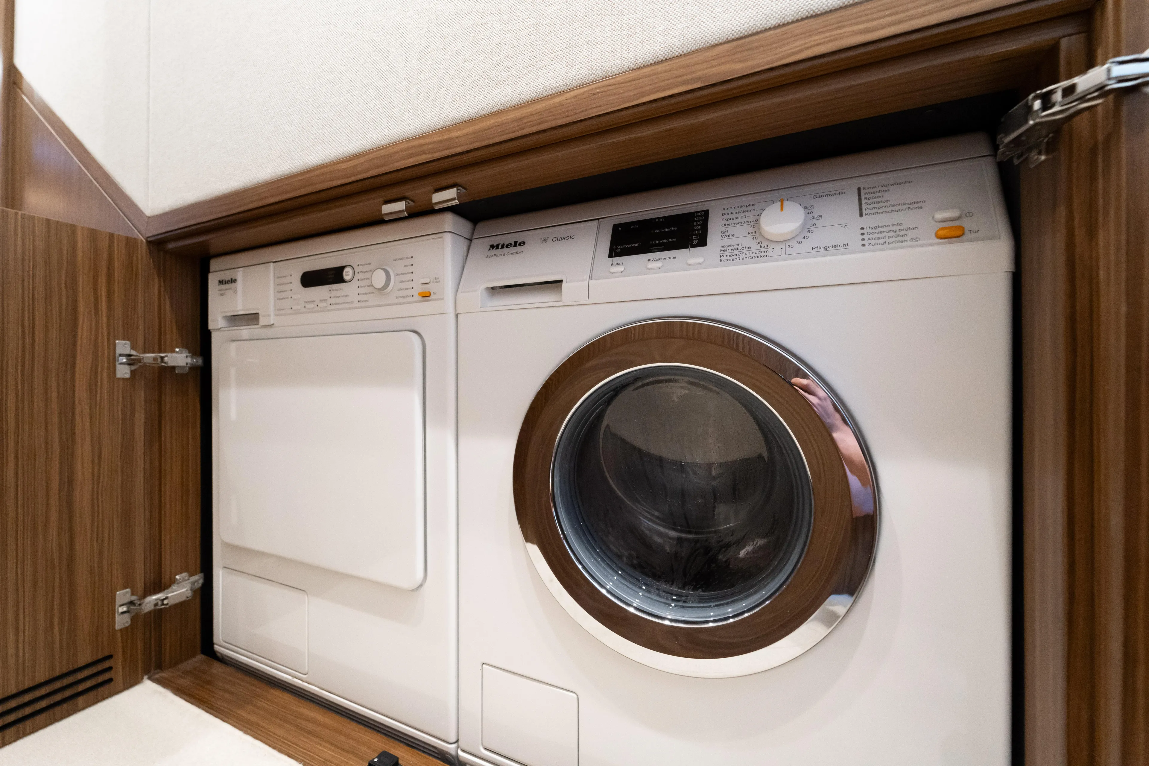 Izi Yacht Photos Pics Laundry appliances in the 2017 Azimut Magellano 66 yacht's wooden cabinet.