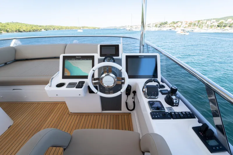 Izi Yacht Photos Pics Helm of 2017 Azimut Magellano 66 yacht with navigation equipment and scenic ocean view.