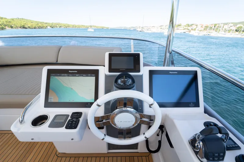 Izi Yacht Photos Pics Helm of 2017 Azimut Magellano 66 yacht with navigation screens and steering wheel.