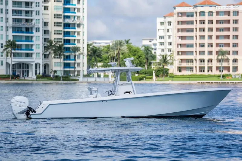  Yacht Photos Pics 2013 Contender 35 ST boat on water, with modern buildings in the background.