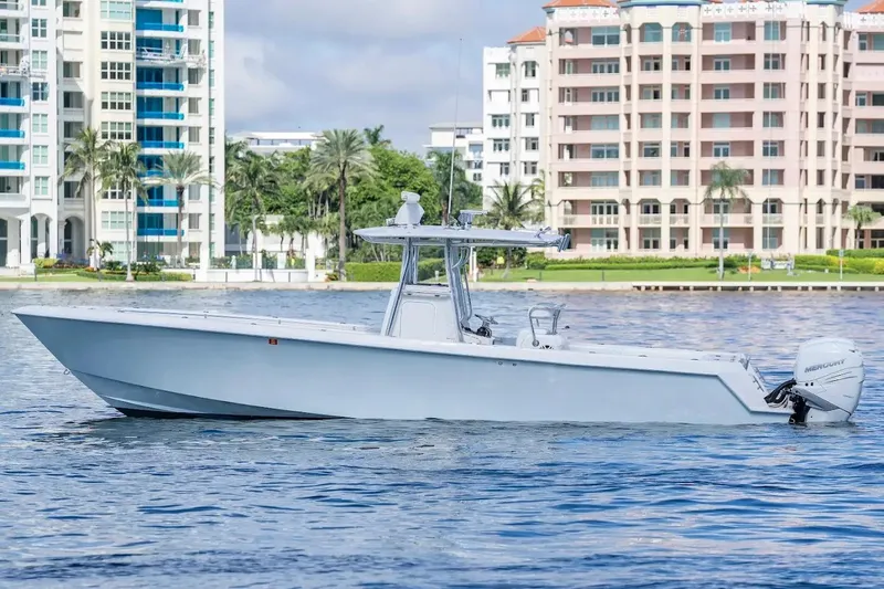  Yacht Photos Pics 2013 Contender 35 ST boat on water, with modern buildings in the background.