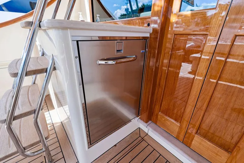 Tutto Bene Yacht Photos Pics 2018 Palm Beach Motor Yachts PB55 Flybridge, stainless steel appliance, wooden cabinetry, and stairs.