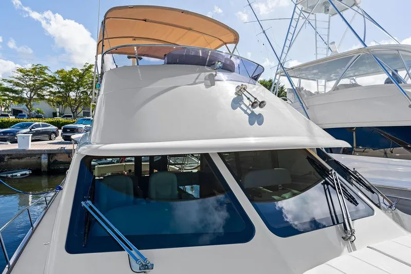 Tutto Bene Yacht Photos Pics 2018 Palm Beach Motor Yachts PB55 Flybridge docked, showcasing sleek design and flybridge canopy.