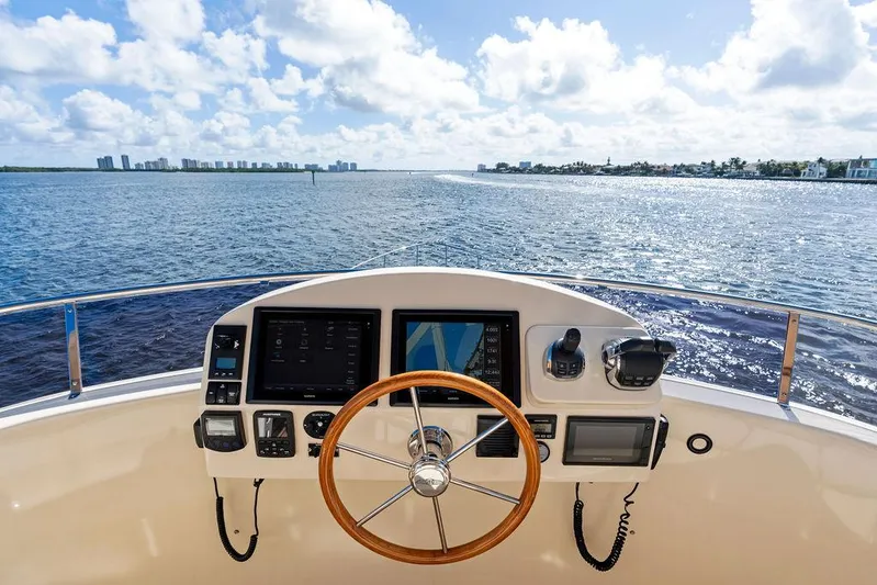 Tutto Bene Yacht Photos Pics 2018 Palm Beach Motor Yachts PB55 Flybridge helm with ocean view, featuring navigation controls.