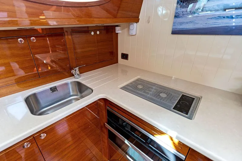 Tutto Bene Yacht Photos Pics Luxurious kitchen area in 2018 Palm Beach Motor Yachts PB55 Flybridge with sleek wood cabinetry.