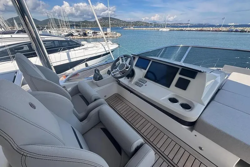  Yacht Photos Pics Luxurious 2023 Absolute 60 Fly yacht helm with modern controls and scenic marina view.