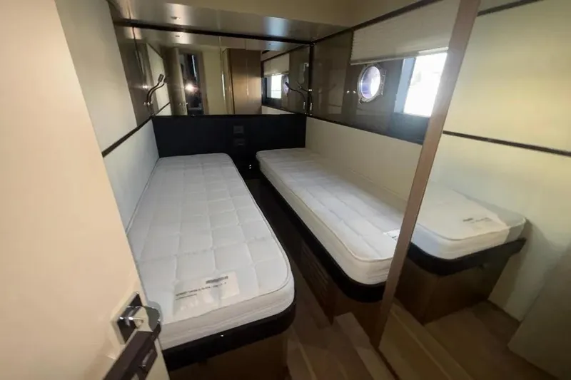  Yacht Photos Pics 2023 Absolute 60 Fly yacht cabin with twin beds and porthole window.
