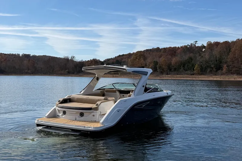  Yacht Photos Pics 2026 Sea Ray SLX 310 boat cruising on a serene lake with autumn foliage.