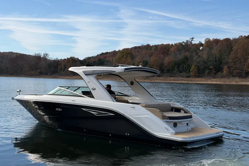  Yacht Photos Pics 2026 Sea Ray SLX 310 boat cruising on a serene lake with autumn foliage.