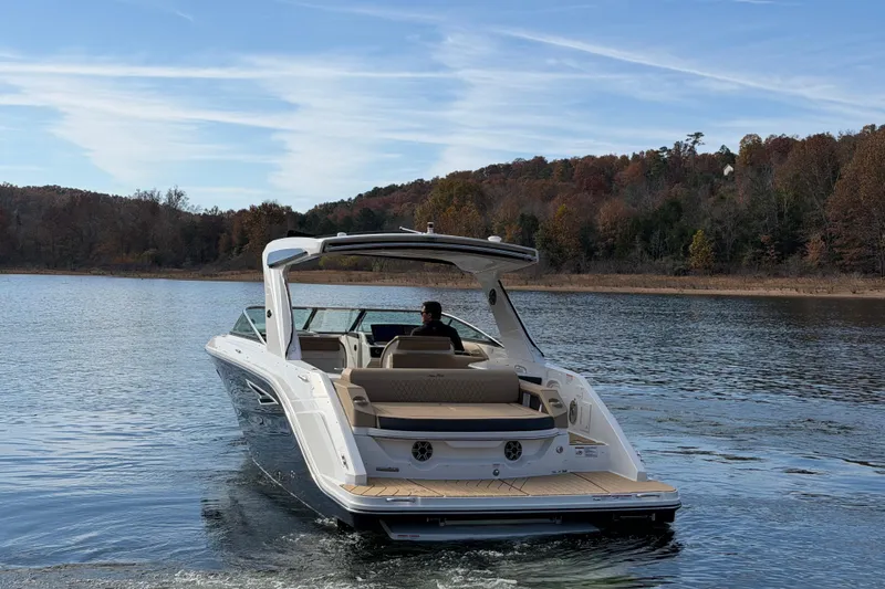  Yacht Photos Pics 2026 Sea Ray SLX 310 cruising on a serene lake with autumn foliage.