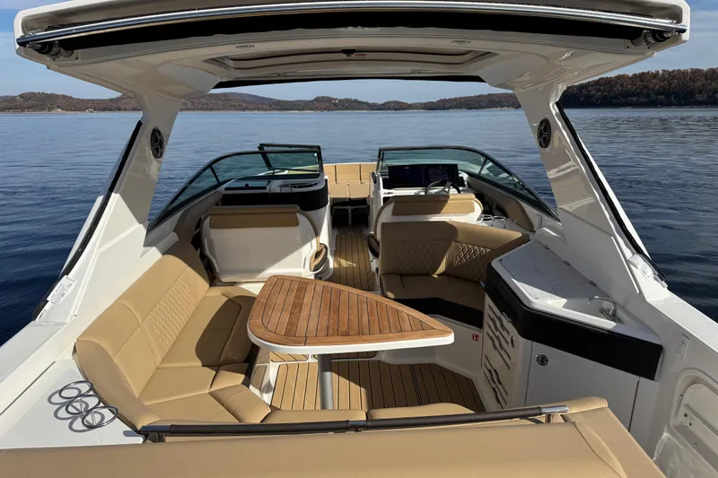  Yacht Photos Pics 2026 Sea Ray SLX 310 boat interior with luxurious seating and wooden table on calm water.