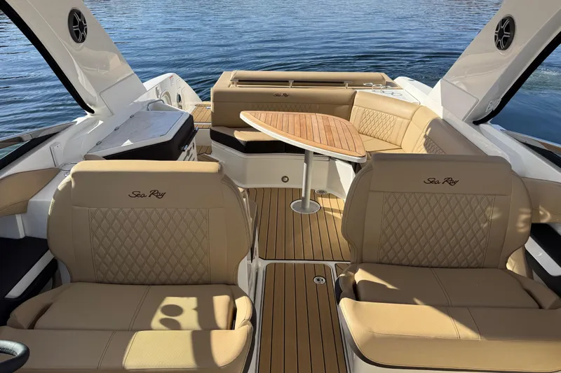  Yacht Photos Pics 2026 Sea Ray SLX 310 boat interior with tan leather seating and wooden table on water.