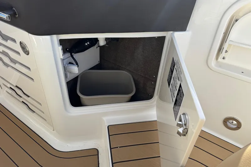  Yacht Photos Pics Open storage compartment on 2026 Sea Ray SLX 310 boat with a bin inside.