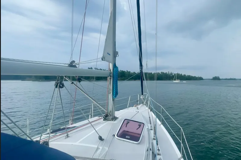 Quest Yacht Photos Pics Sailing on a 2004 Catalina 350 yacht in calm waters under a cloudy sky.