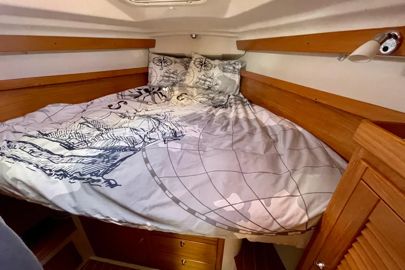 Quest Yacht Photos Pics Cozy cabin interior of 2004 Catalina 350 sailboat with nautical-themed bedding.