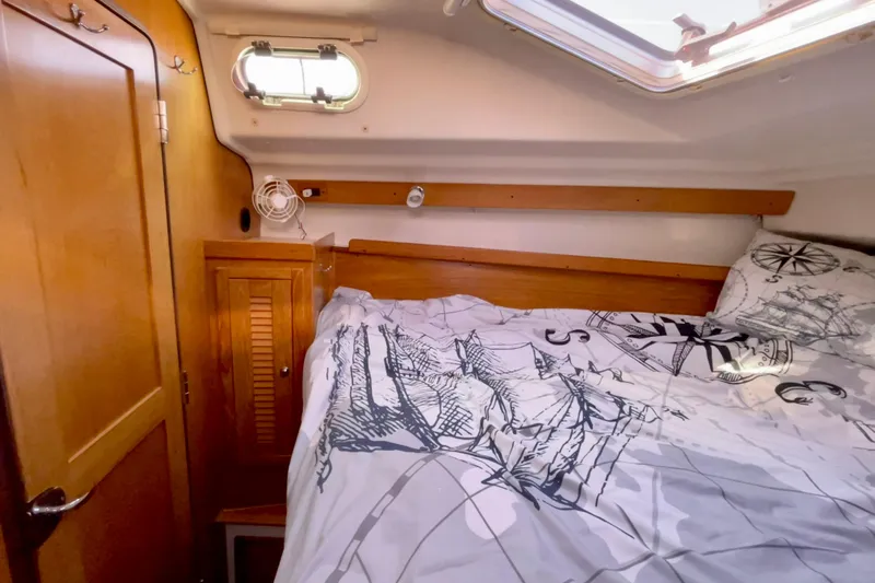 Quest Yacht Photos Pics Cozy cabin interior of 2004 Catalina 350 sailboat with nautical-themed bedding.