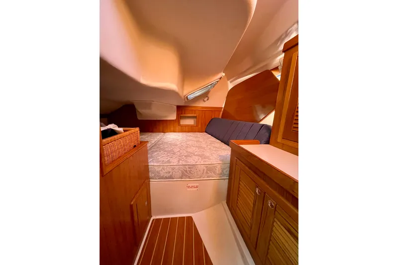 Quest Yacht Photos Pics Cozy cabin interior of a 2004 Catalina 350 sailboat with wooden furnishings.