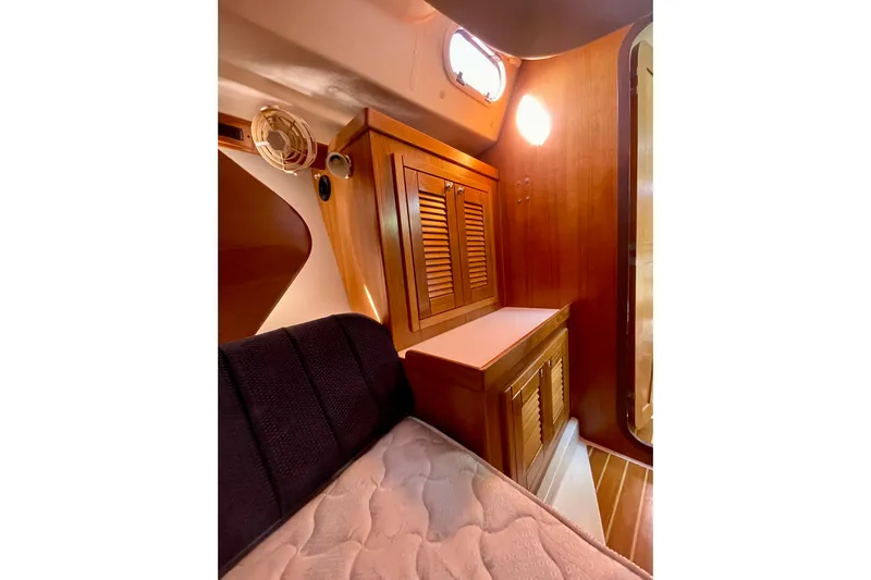 Quest Yacht Photos Pics Interior of 2004 Catalina 350 sailboat with wooden cabinetry and cozy sleeping area.