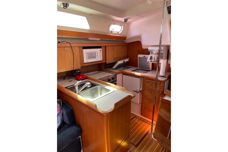 Quest Yacht Photos Pics Interior of 2004 Catalina 350 sailboat kitchen with wooden cabinetry and modern appliances.
