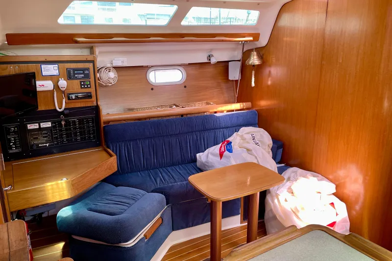 Quest Yacht Photos Pics Interior of a 2004 Catalina 350 sailboat with blue seating and wooden accents.