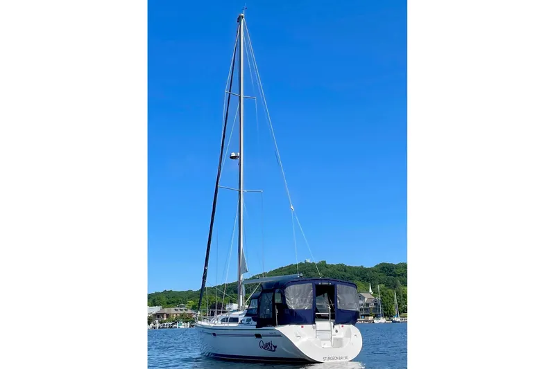 Quest Yacht Photos Pics 2004 Catalina 350 sailboat on calm water with clear blue sky background.