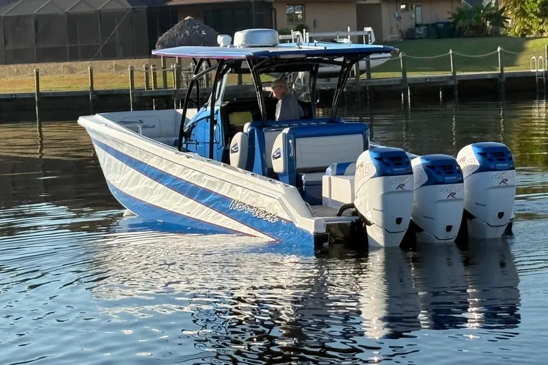  Yacht Photos Pics 2023 Nor-Tech 390 Sport Center Console boat with triple engines on calm water.