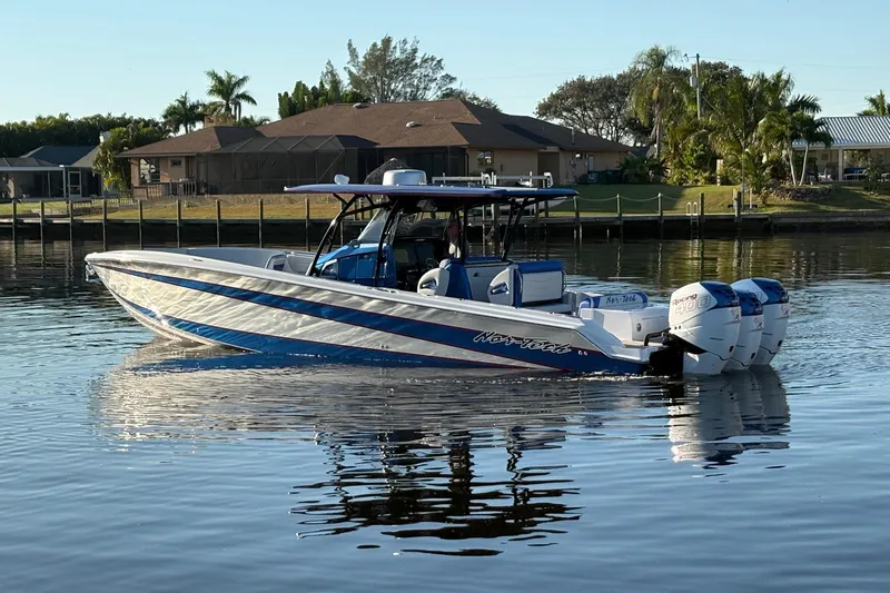  Yacht Photos Pics 2023 Nor-Tech 390 Sport Center Console boat on calm water, residential backdrop.