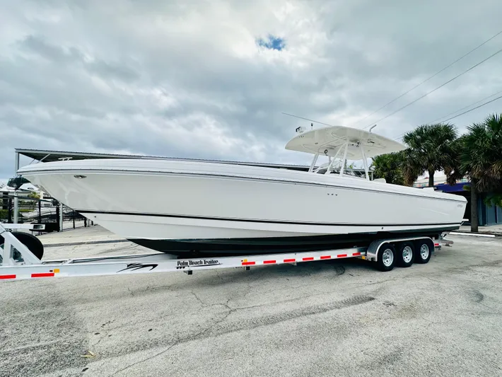 Yacht Photos Pics 2004 Intrepid 370 Open boat on trailer, parked outdoors under cloudy sky.