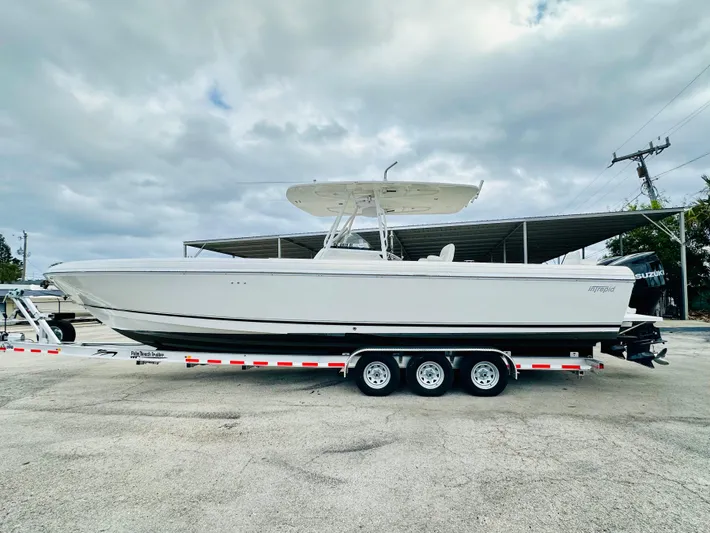  Yacht Photos Pics 2004 Intrepid 370 Open boat on trailer under cloudy sky.