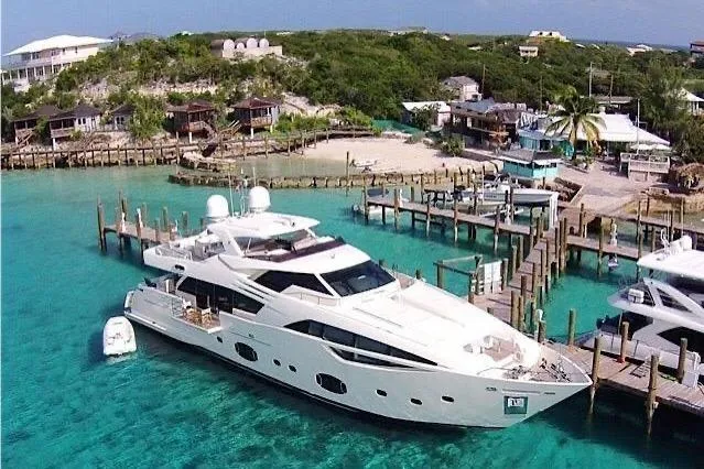 Sha Sha Sha IV Yacht Photos Pics Luxurious 2014 Custom Line 100 yacht docked in tropical marina with clear turquoise waters.