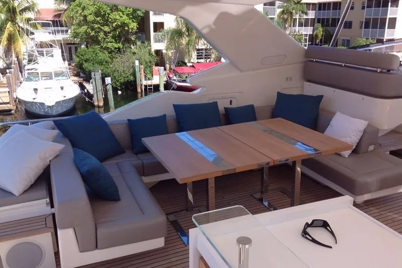 Sha Sha Sha IV Yacht Photos Pics Luxurious 2014 Custom Line 100 yacht deck with seating and table, docked near waterfront.