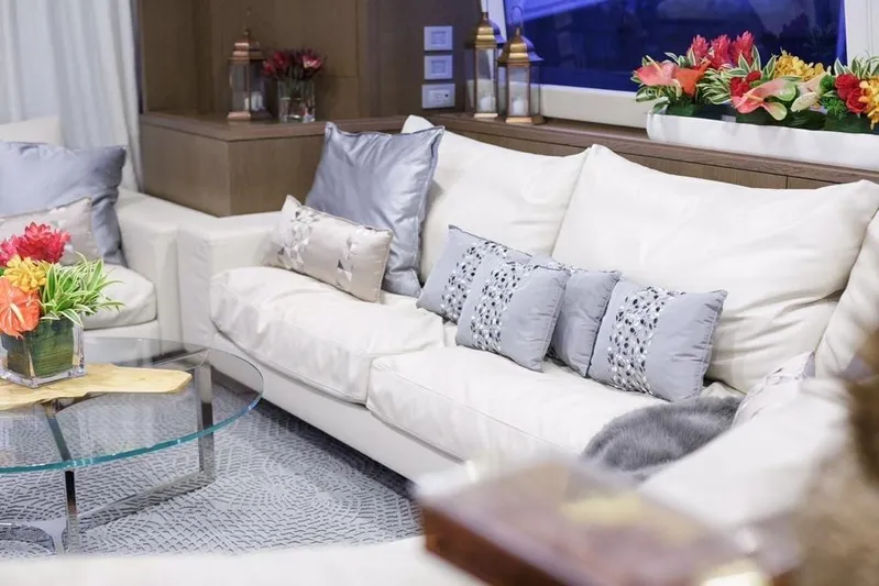 Sha Sha Sha IV Yacht Photos Pics Luxurious yacht interior with elegant white sofas, decorative pillows, and vibrant floral arrangements, Custom Line 100, 2014.