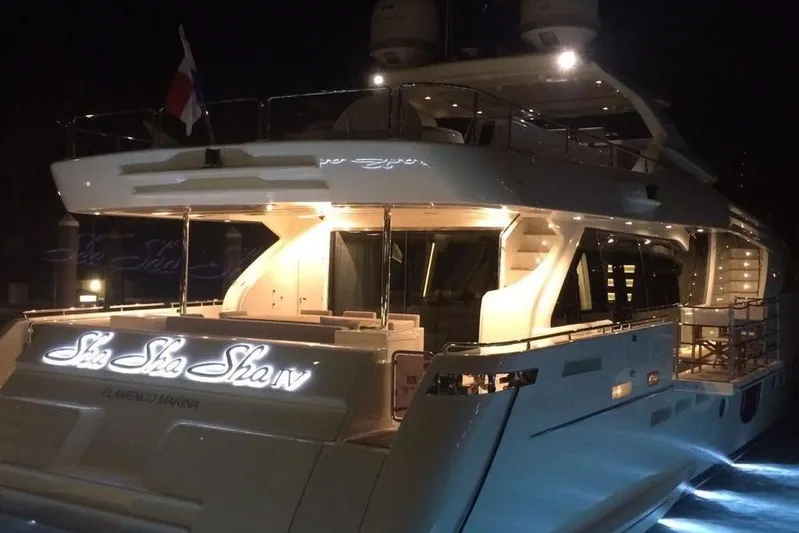 Sha Sha Sha IV Yacht Photos Pics Luxurious 2014 Custom Line 100 yacht illuminated at night, docked at a marina.