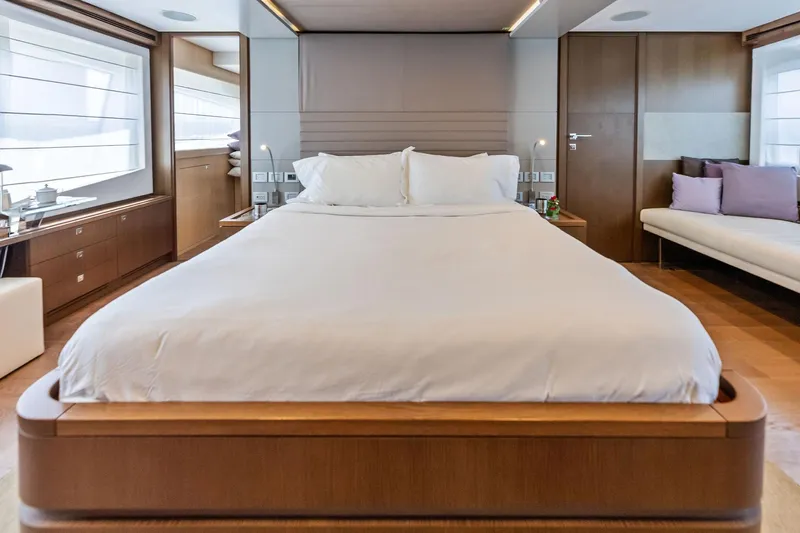 Sha Sha Sha IV Yacht Photos Pics Luxurious bedroom interior on a 2014 Custom Line 100 yacht, featuring elegant wood finishes.