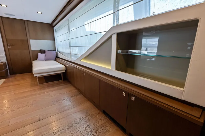 Sha Sha Sha IV Yacht Photos Pics Luxurious yacht interior with wooden flooring, modern shelving, and a comfortable lounge area, Custom Line 100.