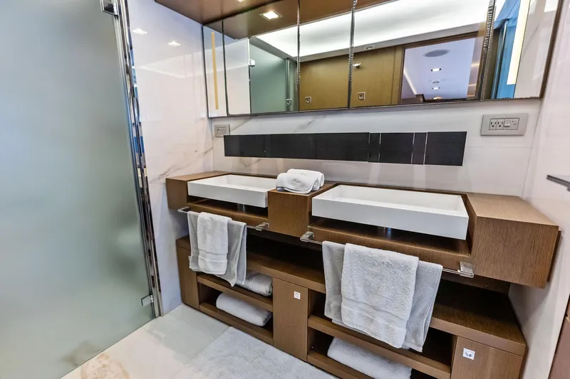 Sha Sha Sha IV Yacht Photos Pics Luxurious modern bathroom with dual sinks, wooden cabinetry, and mirrored storage, Custom Line 100 yacht, 2014.