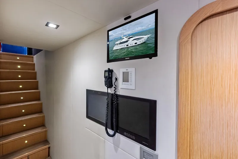 Sha Sha Sha IV Yacht Photos Pics Interior of 2014 Custom Line 100 yacht with stairs, TV, and control panel.