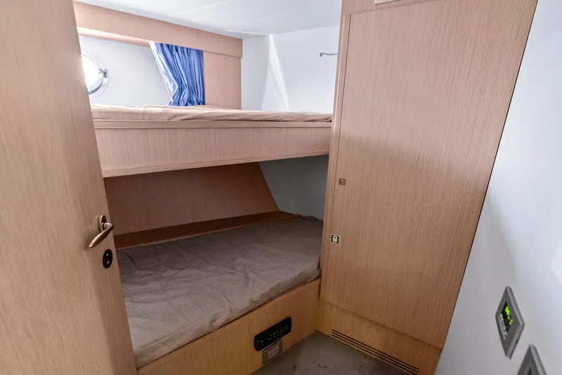 Sha Sha Sha IV Yacht Photos Pics Compact cabin with wooden bunk beds in a 2014 Custom Line 100 yacht.