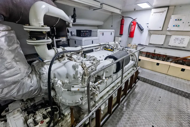 Sha Sha Sha IV Yacht Photos Pics Engine room of a 2014 Custom Line 100 yacht, featuring a large engine and safety equipment.