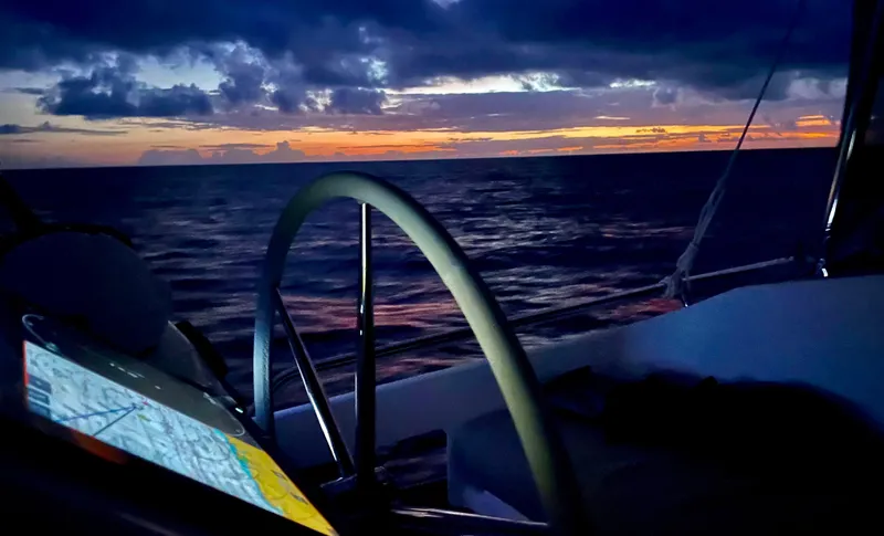 Carpe Aura Yacht Photos Pics Helia 44 catamaran at sunset, featuring navigation equipment and ocean view.